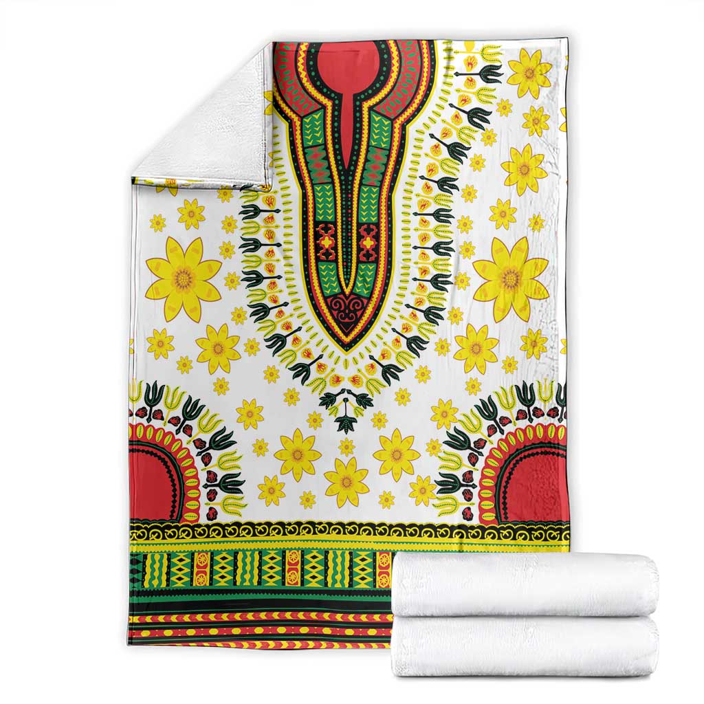 White dashiki blanket folded with yellow flowers and red green multicolor geometric border