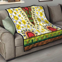 White dashiki quilt on a sofa, with yellow flowers, red arch motifs, and multicolor stripe trim