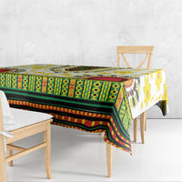 Rectangular tablecloth draped over dining table, green geometric band with red edging