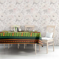 Green, yellow, and red patterned tablecloth with black stripes and scattered flower print