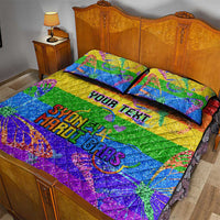Rainbow glitter quilt set with two pillows on a wooden bed, Pride text across center