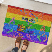 Rainbow glitter rubber doormat with YOUR TEXT and Sydney Mardi Gras design, shown with shoes.