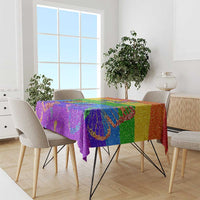 Rainbow glitter pride tablecloth draped over round table with colorful floral print