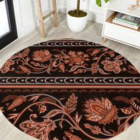 Round traditional patterned carpet with dark background, orange floral ornaments and border
