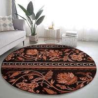 Round traditional patterned carpet with ornate orange damask flowers on dark base