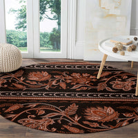 Round traditional carpet featuring orange botanical scrollwork and a striped decorative border