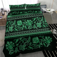 Green bedding set spread on bed, repeating leaf and buta floral ornament with border stripes
