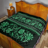 Green traditional bed quilt with dark background and large ornate floral vine design