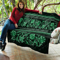 Green quilt held up showing horizontal stripes, teal floral vines, and quilted stitching
