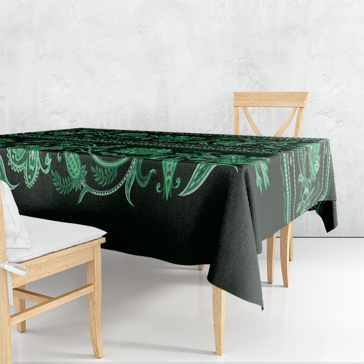 Green traditional tablecloth with flowing floral border, draped over table