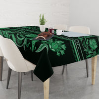 Green traditional tablecloth with large leaf and floral motif, table covered