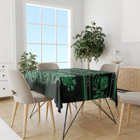 Green traditional tablecloth with floral ornament border, dining table covered