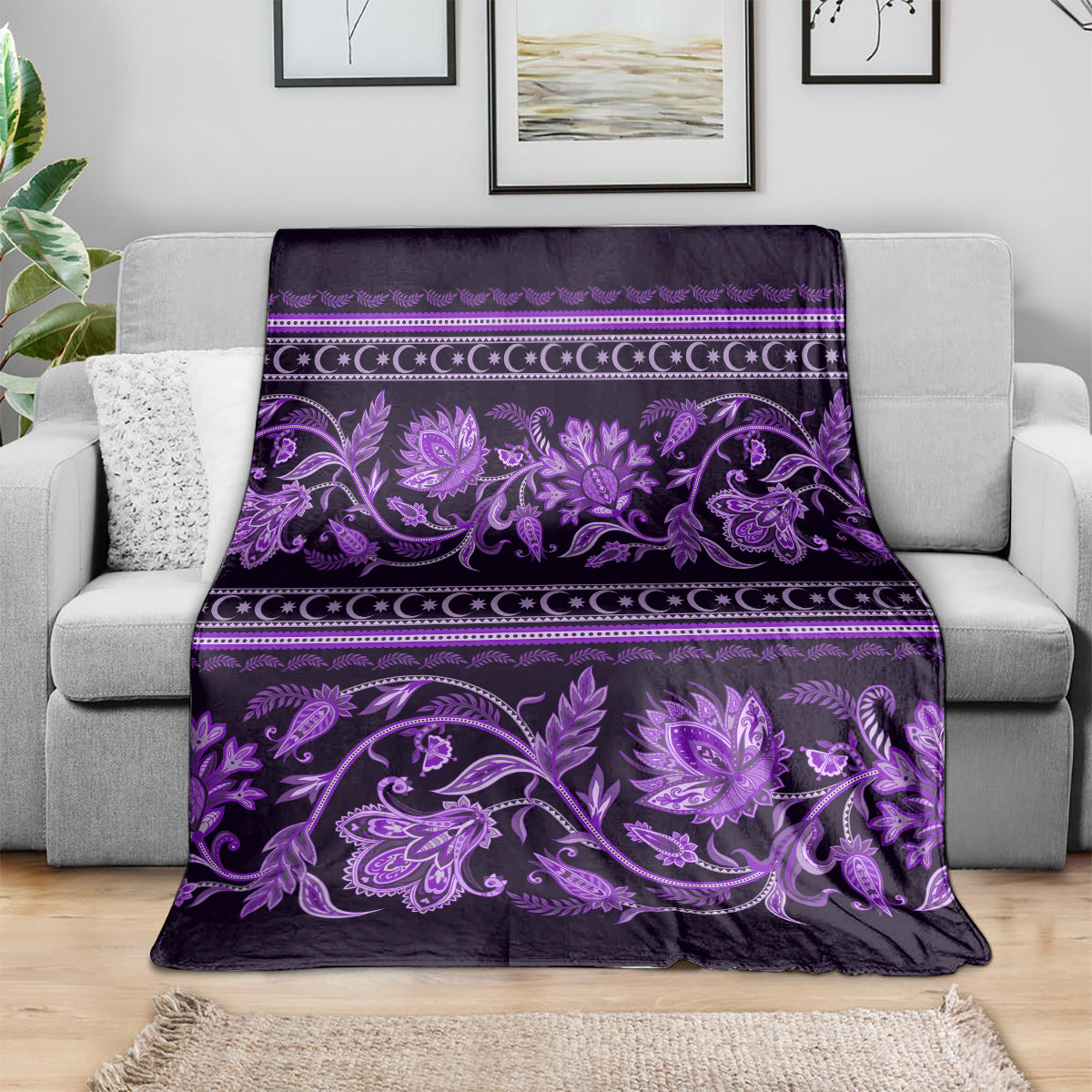 Violet floral ornament throw blanket draped on a sofa, with striped border