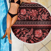 Round beach blanket with white fringe edge, red floral scrolls on dark fabric