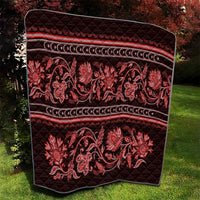 Red quilt with diamond quilting texture, floral paisley print, and striped bands