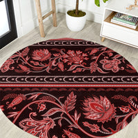 Round red traditional patterned carpet with floral buta motifs and border
