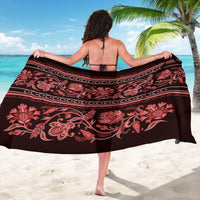 Traditional sarong on model, red floral and paisley motifs with border stripes.