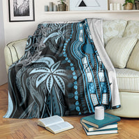 Blue and gray dashiki-pattern blanket draped over sofa, with bold vertical stripe border