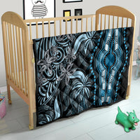 Black and blue dashiki quilt on crib mattress, featuring ornate blue pendant centerpiece