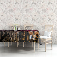 Patterned tablecloth covering table top, purple and black tapestry-style design with floral accents.