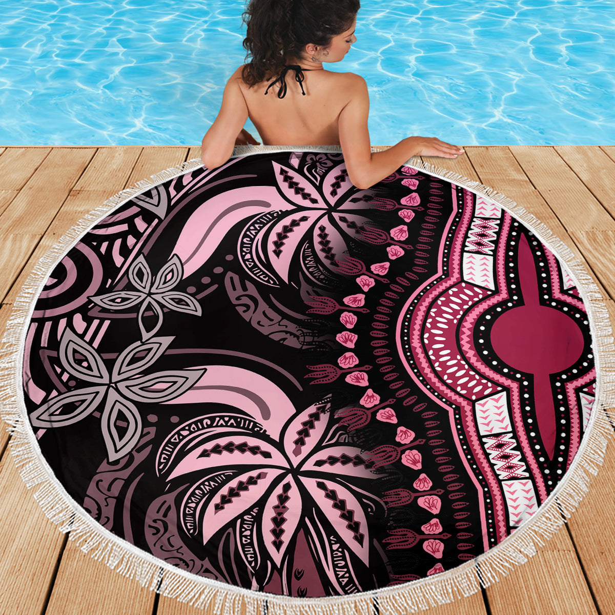 Round pink beach blanket with white tassel fringe and bold black, pink tribal pattern