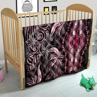 Pink and black dashiki quilt on baby bed with floral pattern and central hand motif