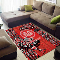 Red area rug featuring bold black-and-white tribal designs and circular center emblem