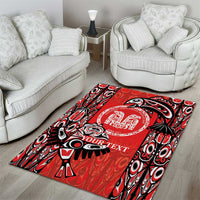 Red tribal area rug with black-and-white pattern border and circular personalization emblem