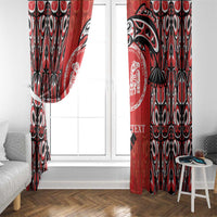 Red and black patterned curtain panels with circular emblem, hanging on a window