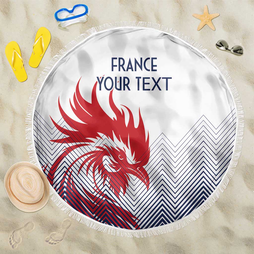 Round white France-themed beach blanket with red rooster graphic and blue chevron pattern, fringe edge