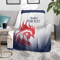 France rugby blanket on sofa, white and dark blue chevron pattern with red rooster and text
