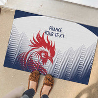 White and navy rubber doormat with red rooster graphic, zigzag pattern, and 'FRANCE YOUR TEXT' underfoot.