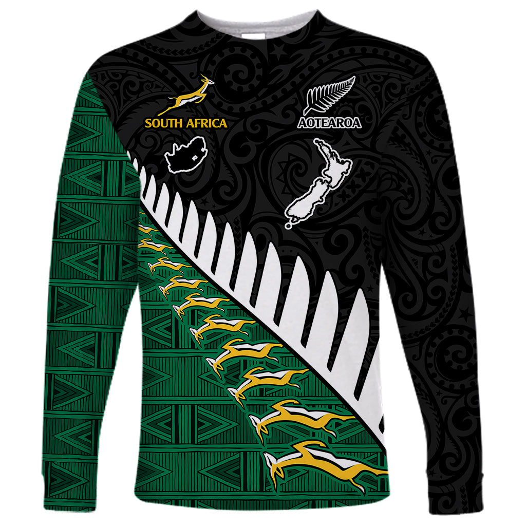 Black long sleeve rugby shirt with green patterned panel, diagonal white stripe and team emblems