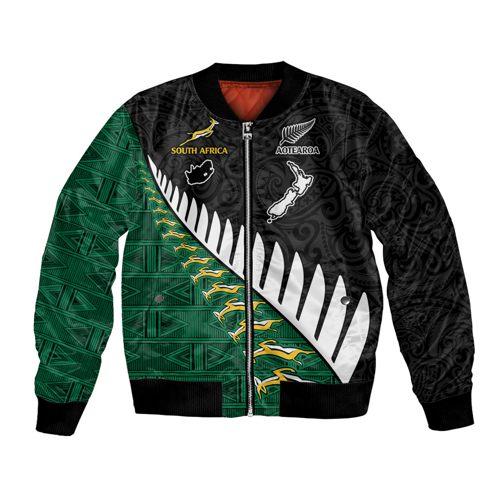 Black unisex bomber jacket with green diagonal panel, zip front, and tribal sports emblems