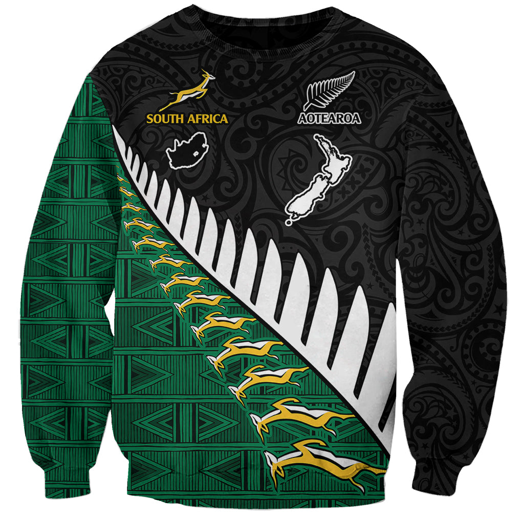 Black crewneck sweatshirt with green diagonal stripe, tribal prints, South Africa and Aotearoa emblems