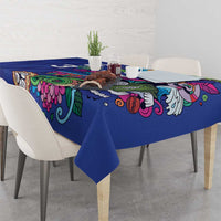 Blue tablecloth with colorful floral and scroll motifs, draped over table edge