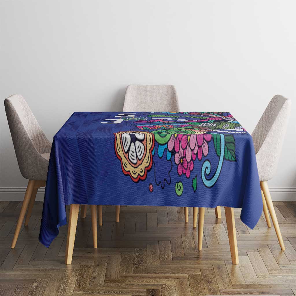 Blue tablecloth with colorful folk motifs, on square dining table