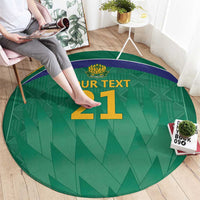 Green round cricket area rug with purple edge and gold '21' numeral, partial view