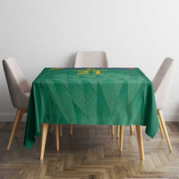 Green cricket tablecloth on dining table with crest motif and “21” at top center