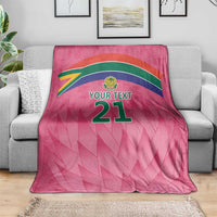 Pink custom cricket blanket with Proteas crest and YOUR TEXT 21, laid on sofa
