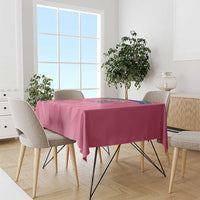 Pink cricket tablecloth draped over dining table with geometric pattern