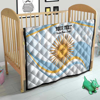 Light blue quilt on a wooden crib with Argentina sun face graphic and custom text