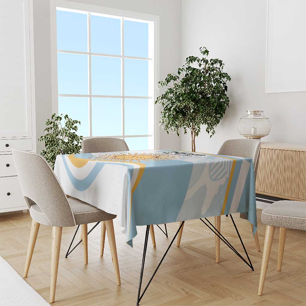Light blue and white tablecloth with sun-themed graphic panel on dining table