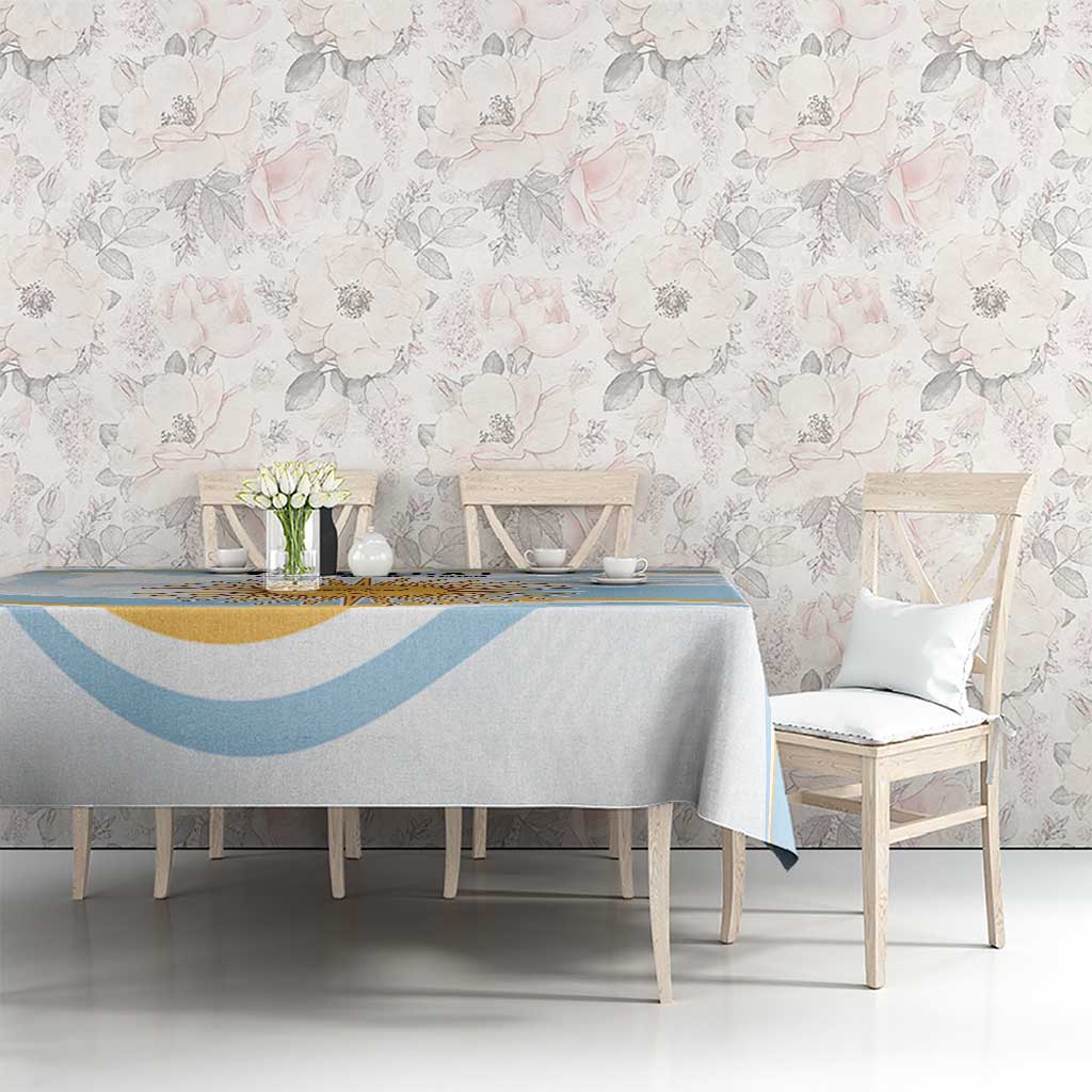 Light blue and white tablecloth with wide decorative border and sunburst motif
