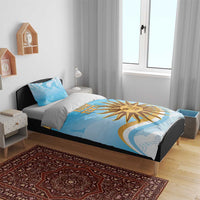 Blue duvet cover set on bed with yellow sun emblem and custom text, matching pillowcases
