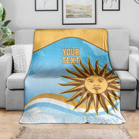 Blue and gold rugby blanket with sun emblem and 'YOUR TEXT' design on a sofa