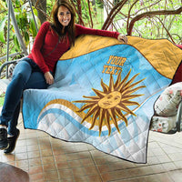 Blue and yellow quilt laid over sofa with sun graphic and diamond quilting, your text