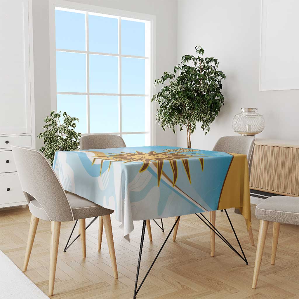 Blue tablecloth with gold sun graphic and abstract shapes on a dining table