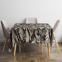 Black and white snake-and-crocodile print tablecloth on dining table with chairs