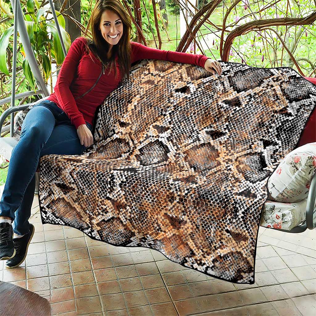 Snake-skin patterned quilt spread out, beige tan with black and white diamond scales